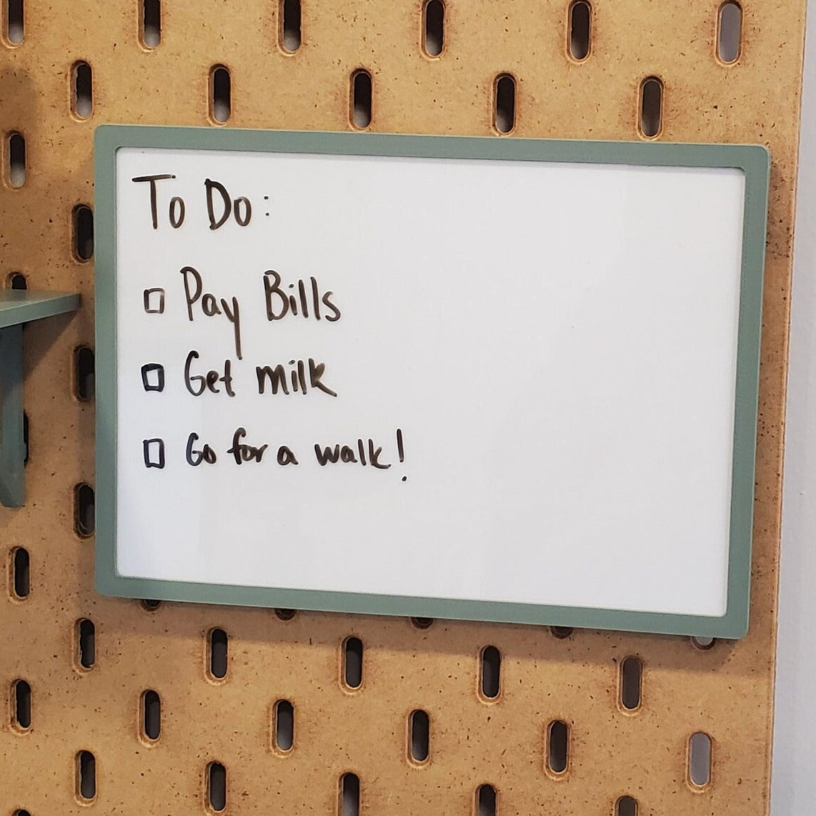 kobieta odhaczająca zadania na kartce przy biurku z kawą obok