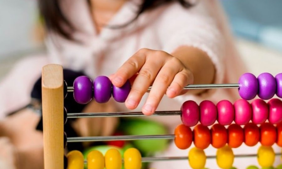 dzieci bawiące się kolorowymi klockami i kostkami przy stole w pokoju