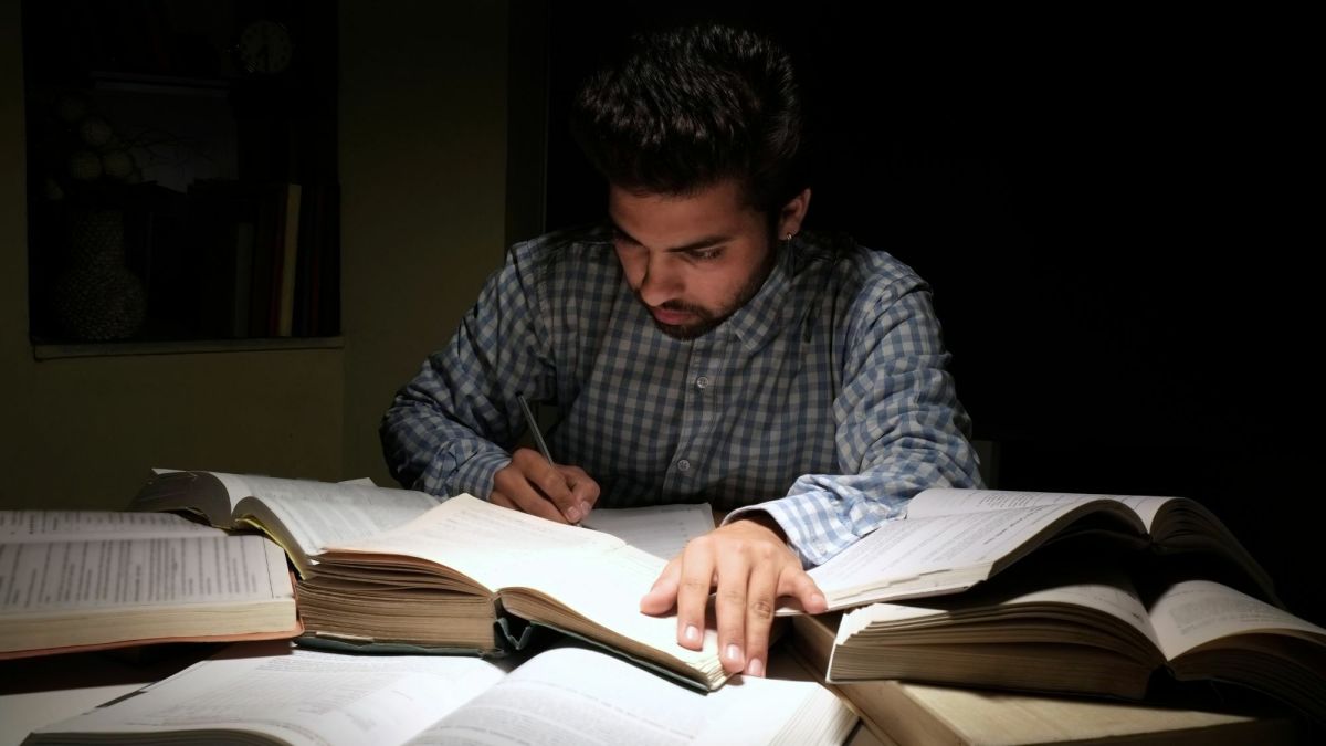 chłopak podkreślający ważne fragmenty w otwartym podręczniku